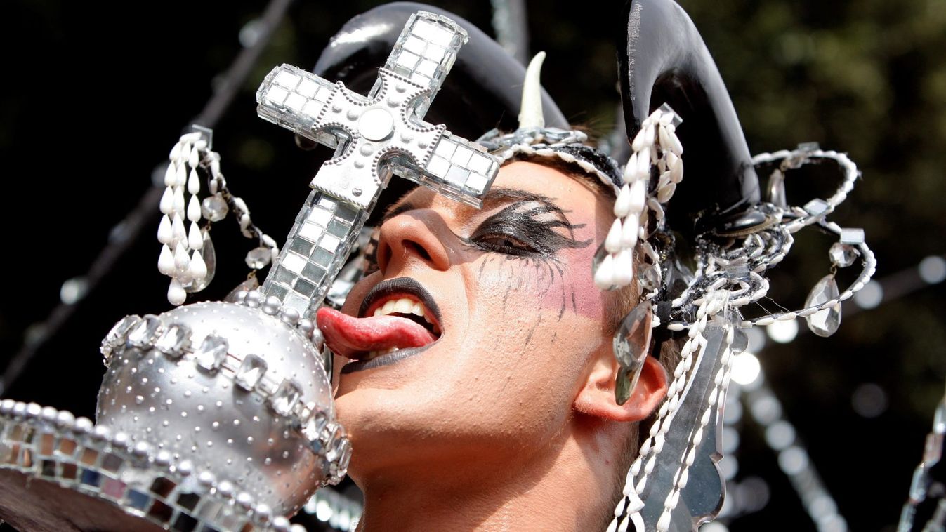A gay-rights activist licks a cross as he takes part in a gay pride parade in Rome