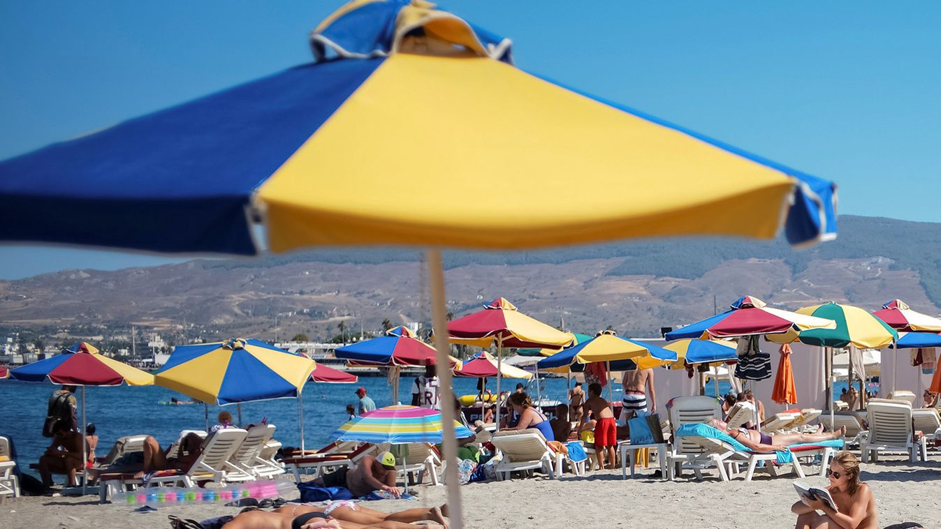 Tourists relax on the beach of Mediterranean Sea at the island of Kos, Greece