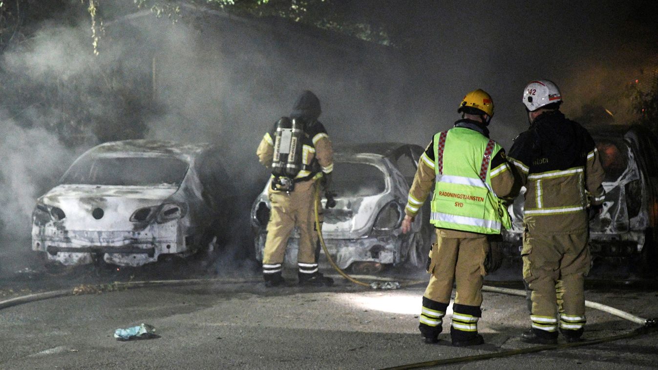 File photo of firefighters extinguishing a fire which had damaged cars after the vehicles had been set alight, in Malmo