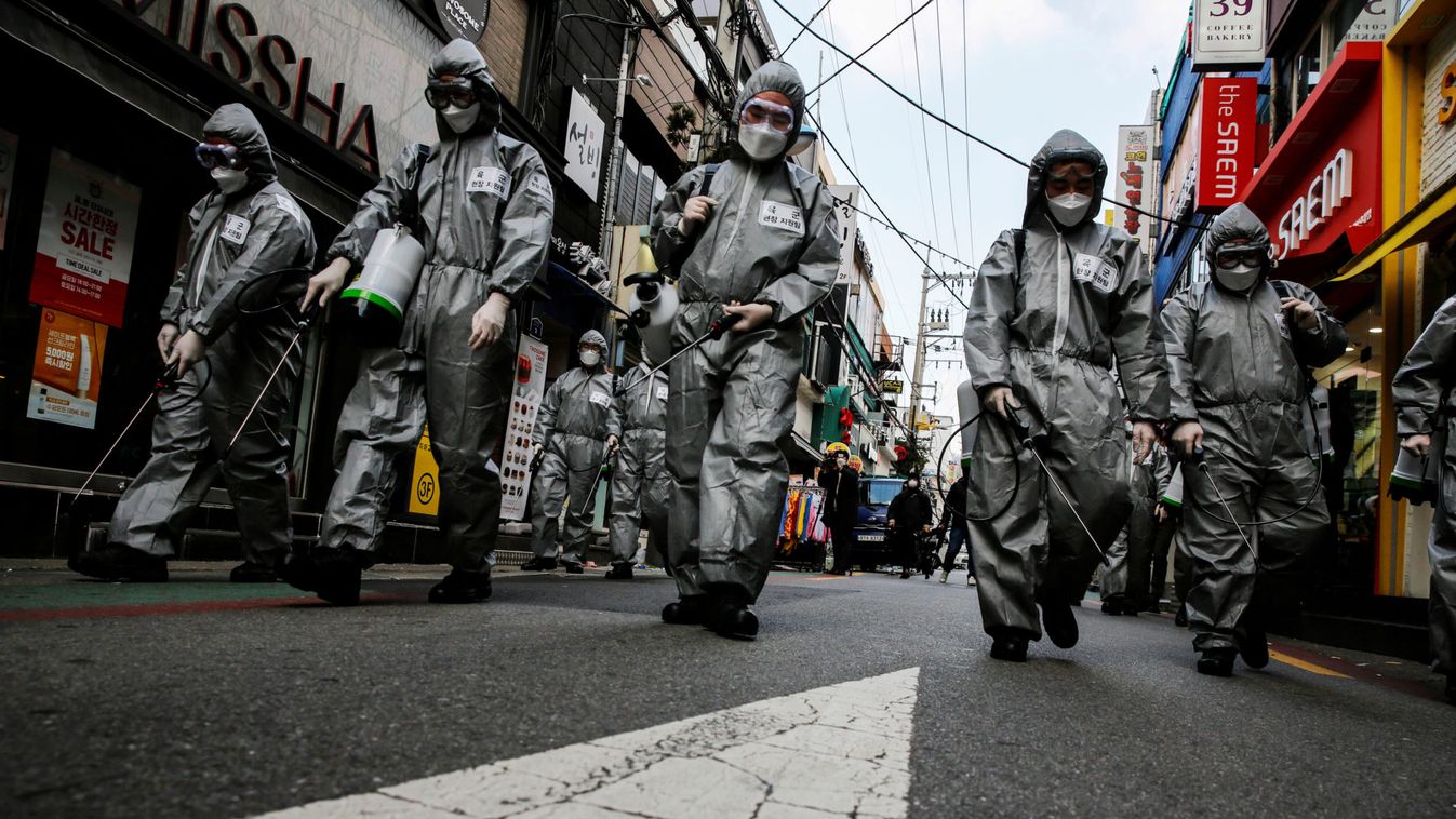 South Korean soldiers in protective gear sanitize a shopping street in Seoul