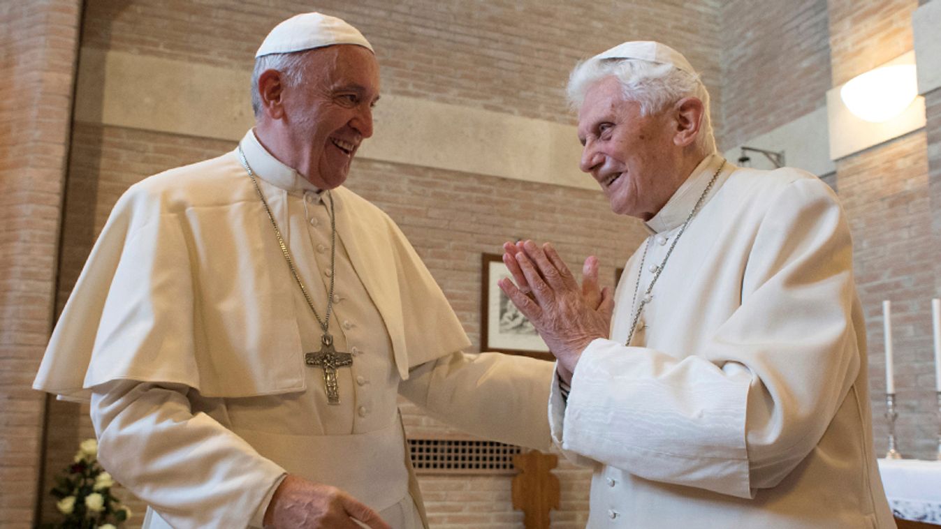 Pope Francis talks to Pope Emeritus Benedict XVI as he introduces him the new cardinals following a consistory ceremony in Saint Peter's Basilica at the Vatican