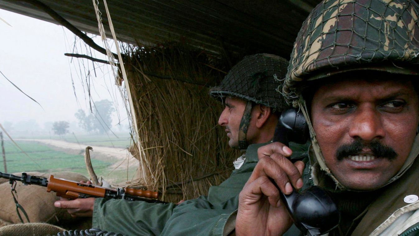 Indian BSF soldiers keep vigil from a bunker near the fenced border with Pakistan in Suchetgarh