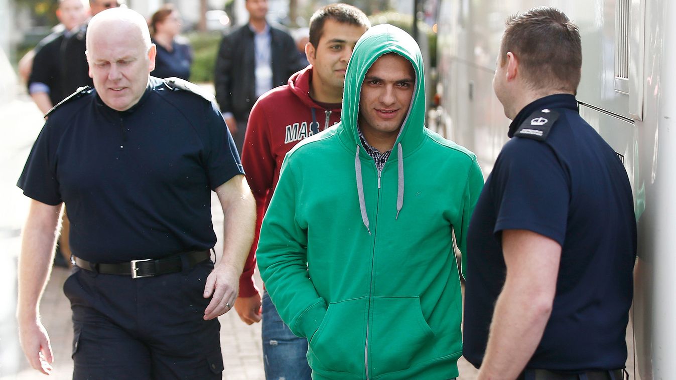 UK Border Force staff escort the first group of unaccompanied minors from the Jungle migrant camp in Calais to be brought to Britain as they arrive at an immigration centre in Croydon, south London