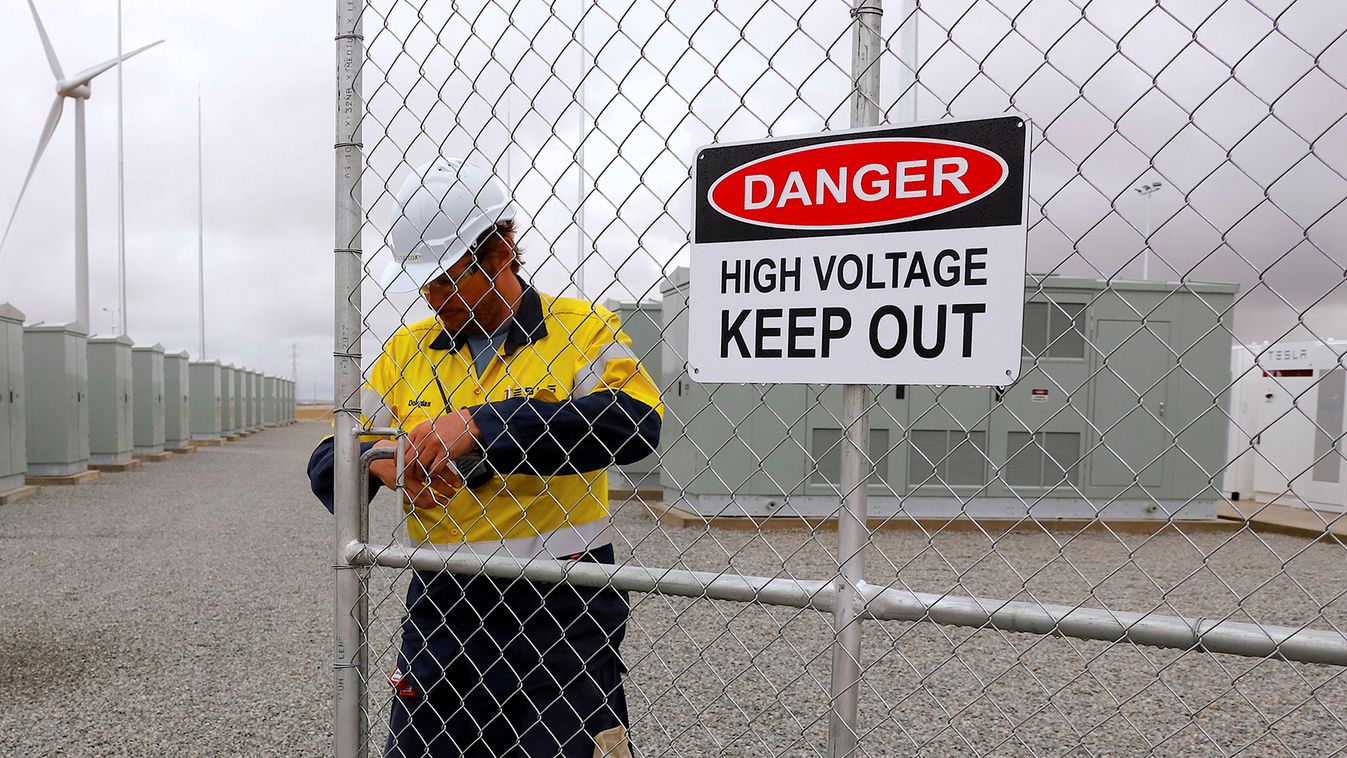  A worker checks the main gate for the compound housing the Hornsdale Power Reserve, featuring the world's largest lithium ion battery made by Tesla, during the official launch near the South Australian town of Jamestown