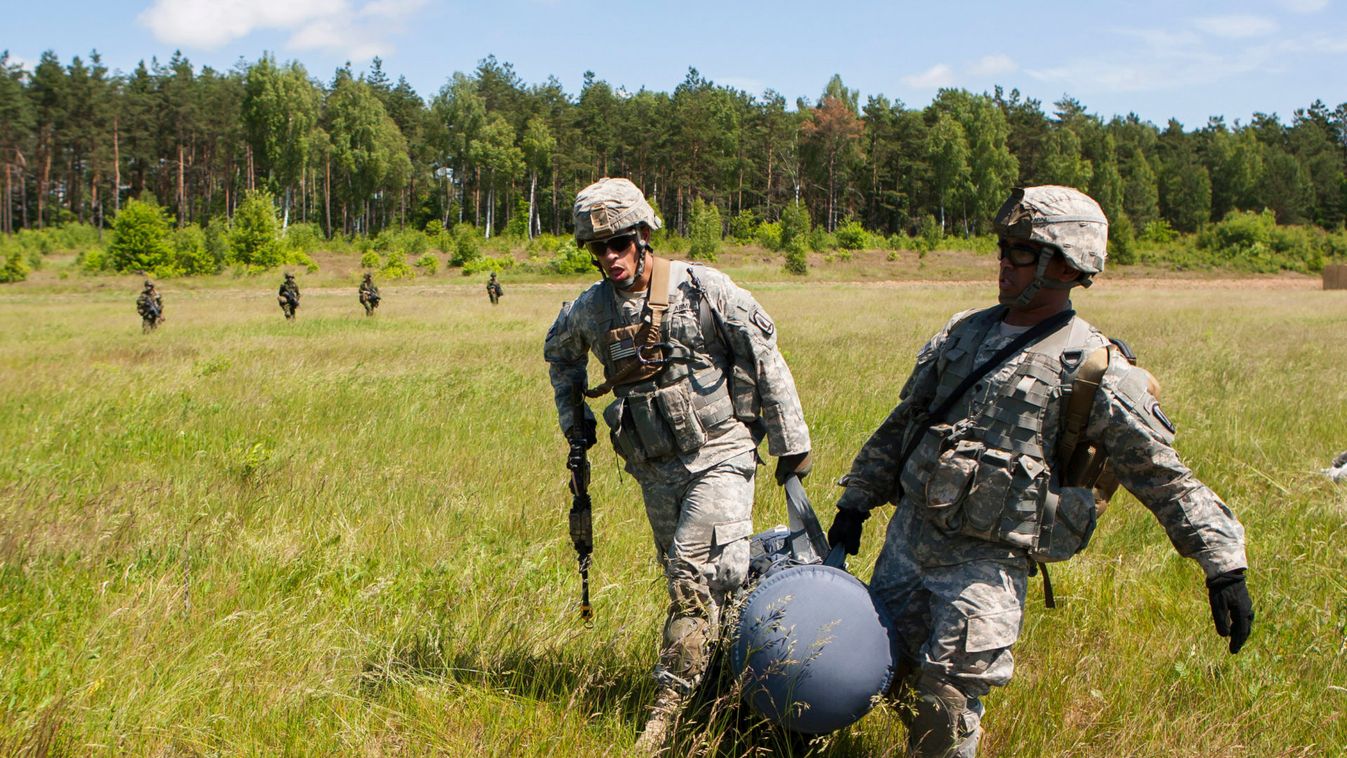 Members of U.S. Army's 173rd Infantry Brigade Combat Team carry cargo bag as during joint training exercises in Oleszno