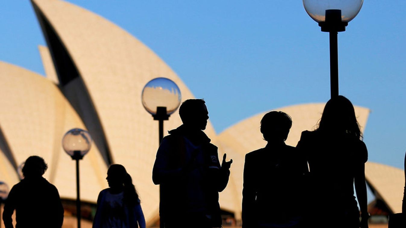 People walk in front of the Sydney Opera House, Australia