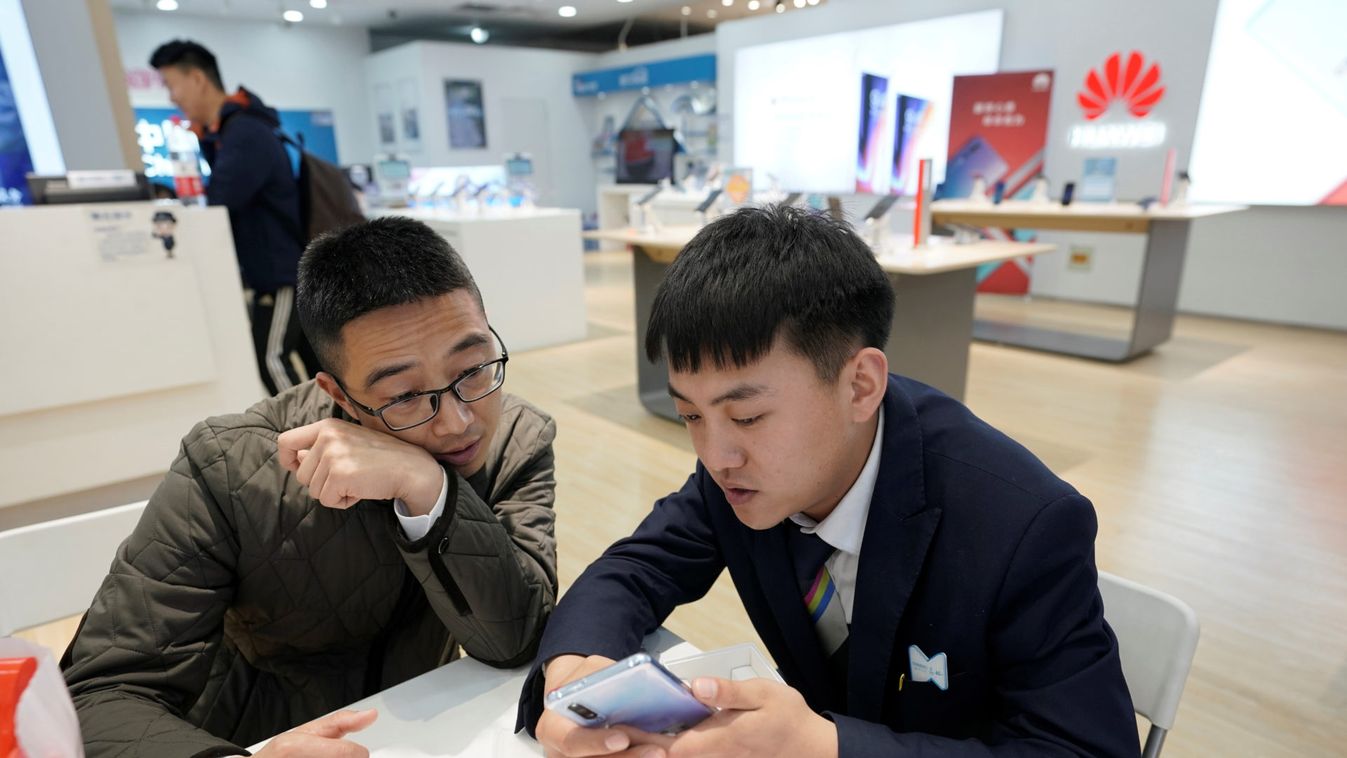 A salesman shows a new Huawei P30 smartphone to a customer in Beijing
