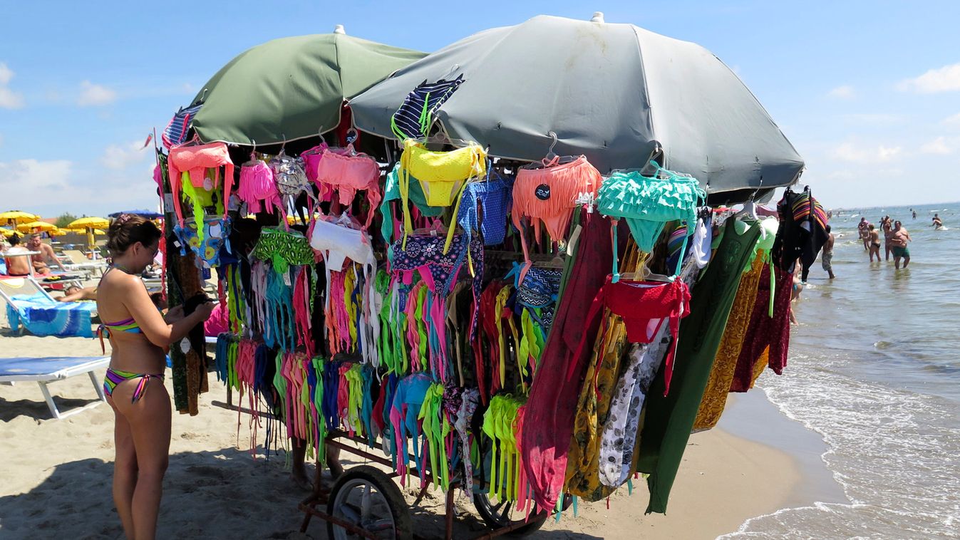 A woman looks at swimsuit on a beach at Maccarese neighbourhood of Rome