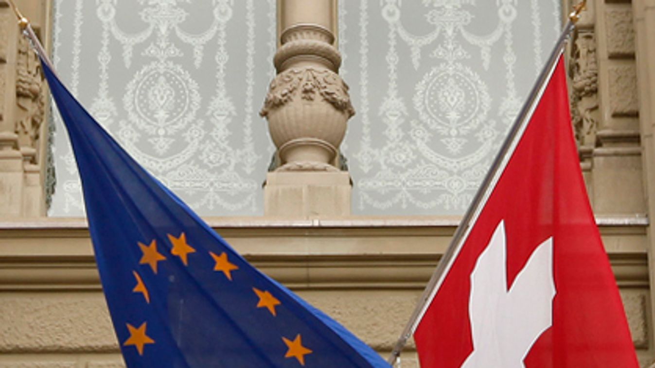 The flags of the European Union and Switzerland flutter in the wind at the Swiss parliament building in Bern