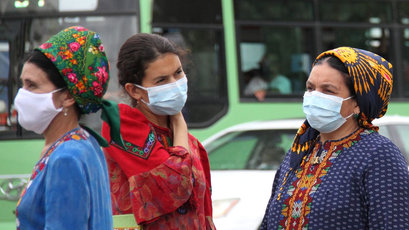 Women wearing protective face masks are seen at a bus stop in Ashgabat
