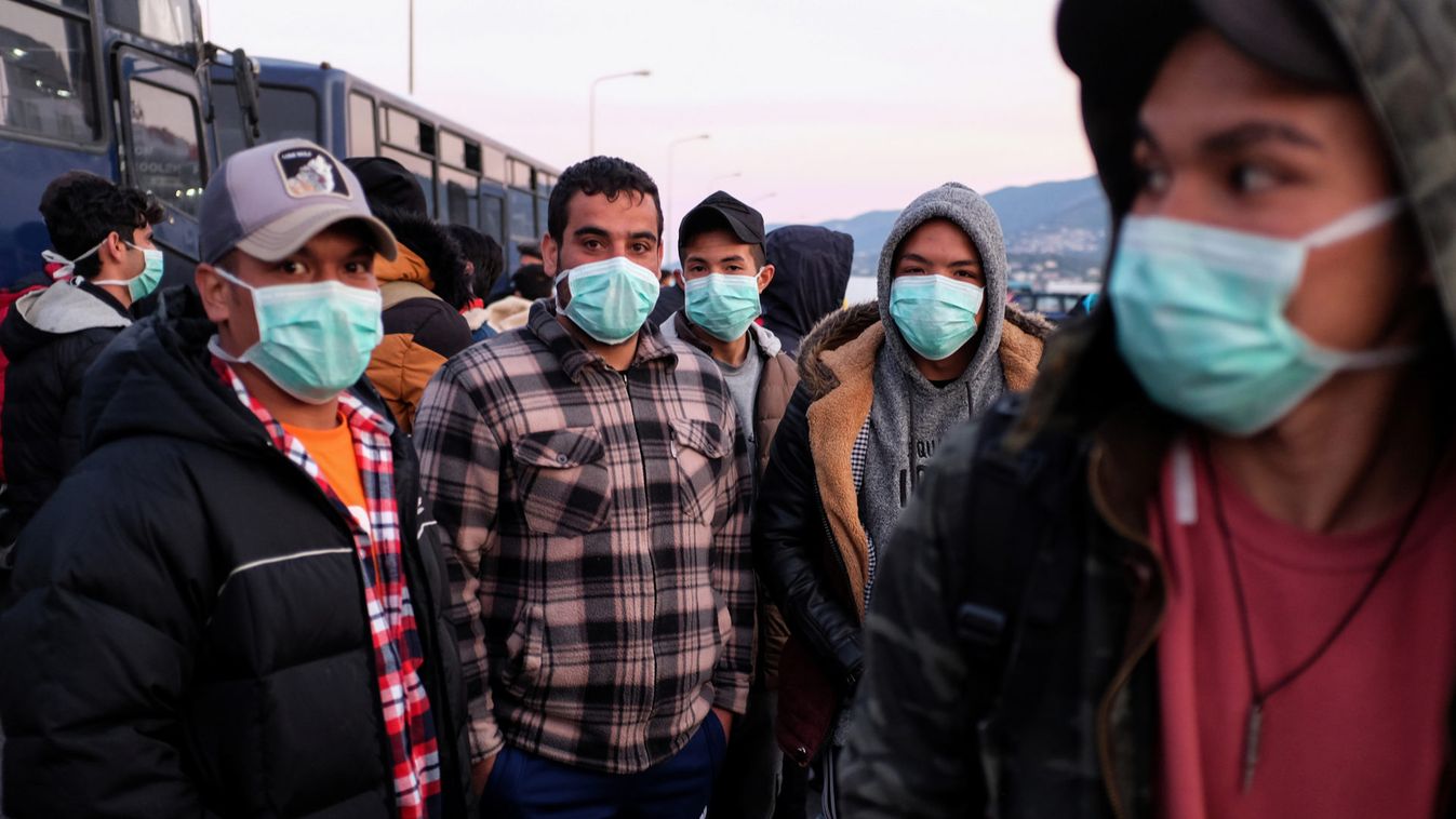 Migrants wearing protective face masks as a precaution against the spread of coronavirus disease (COVID-19), wait to board a ferry that will transfer them to the mainland, at the port of Mytilene on the island of Lesbos
