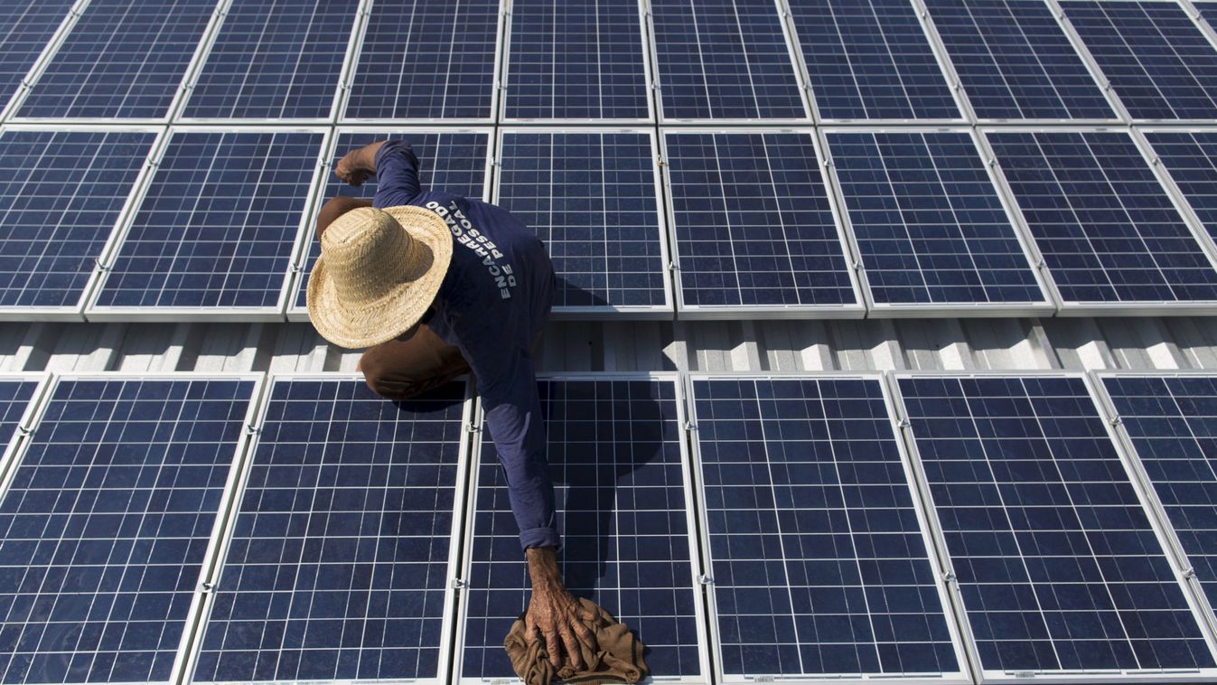 Francisco da Silva Vale cleans solar panels which power ice machines at Vila Nova do Amana community in the Sustainable Development Reserve, in Amazonas state
