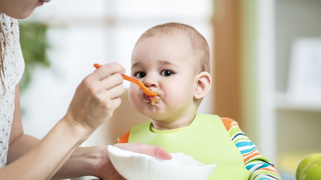 Mother feeding baby with spoon
