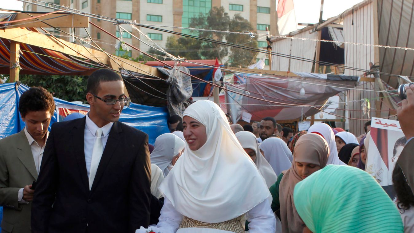 Newly-wed couple, supporters of deposed Egyptian President Mursi, exit the main stage after they held their wedding ceremony at Rabaa Adawiya Square, where Mursi suppoRters are camping, in Nasr city area