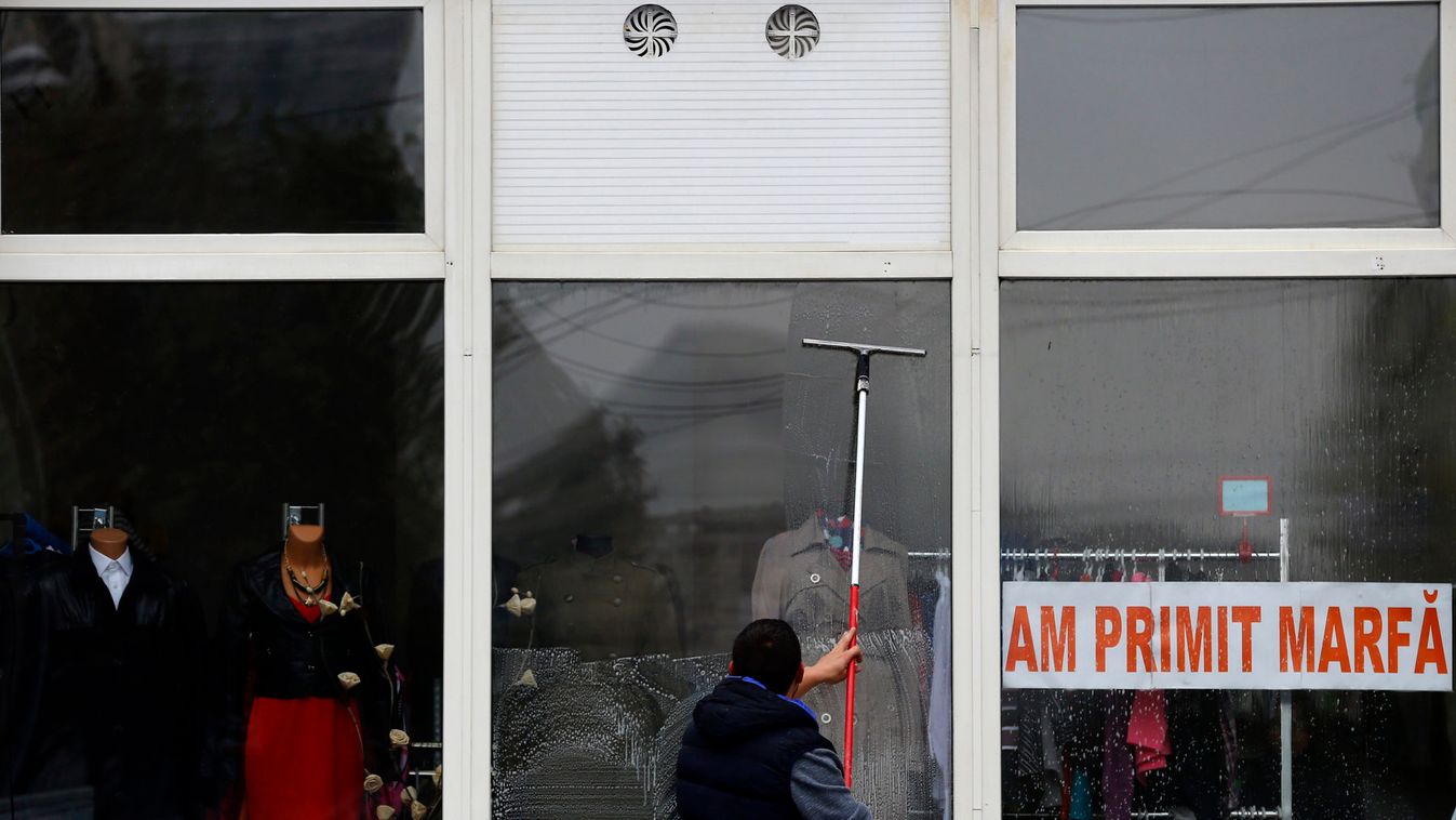 Man cleans the windows of a shop in Bucharest