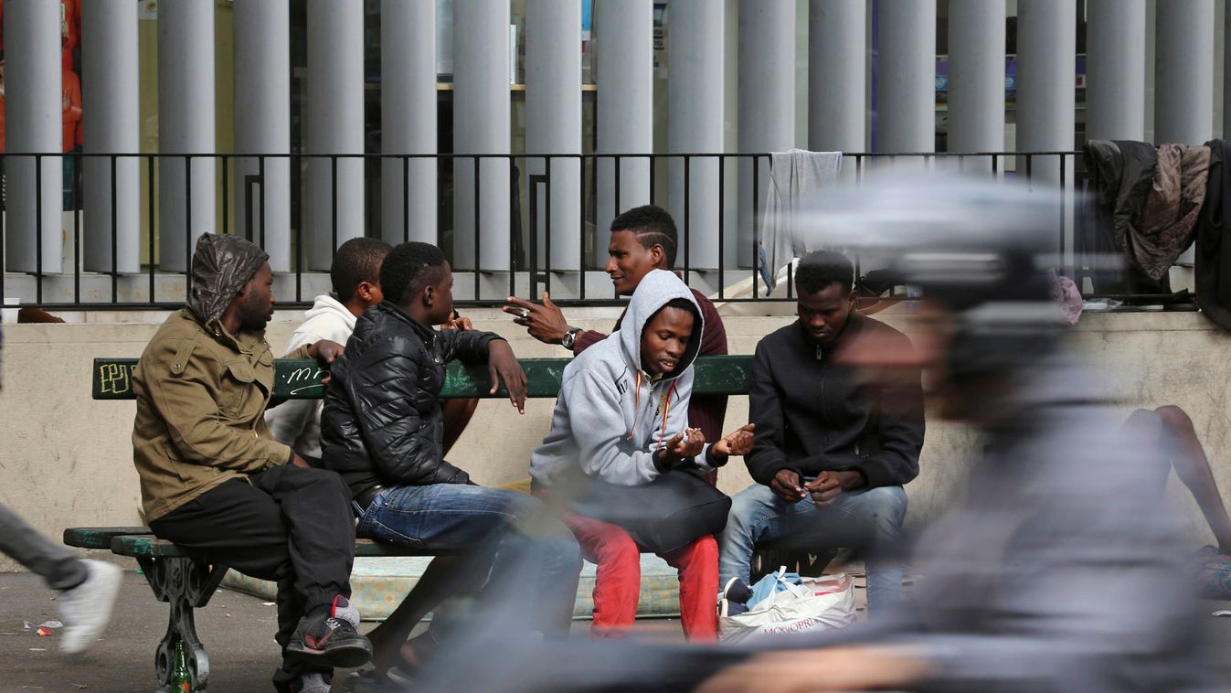 Migrants are seen at a makeshift camp on a street in Paris