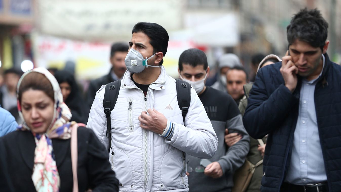 Iranian men wearing protective masks to prevent contracting a coronavirus walk at Grand Bazaar in Tehran