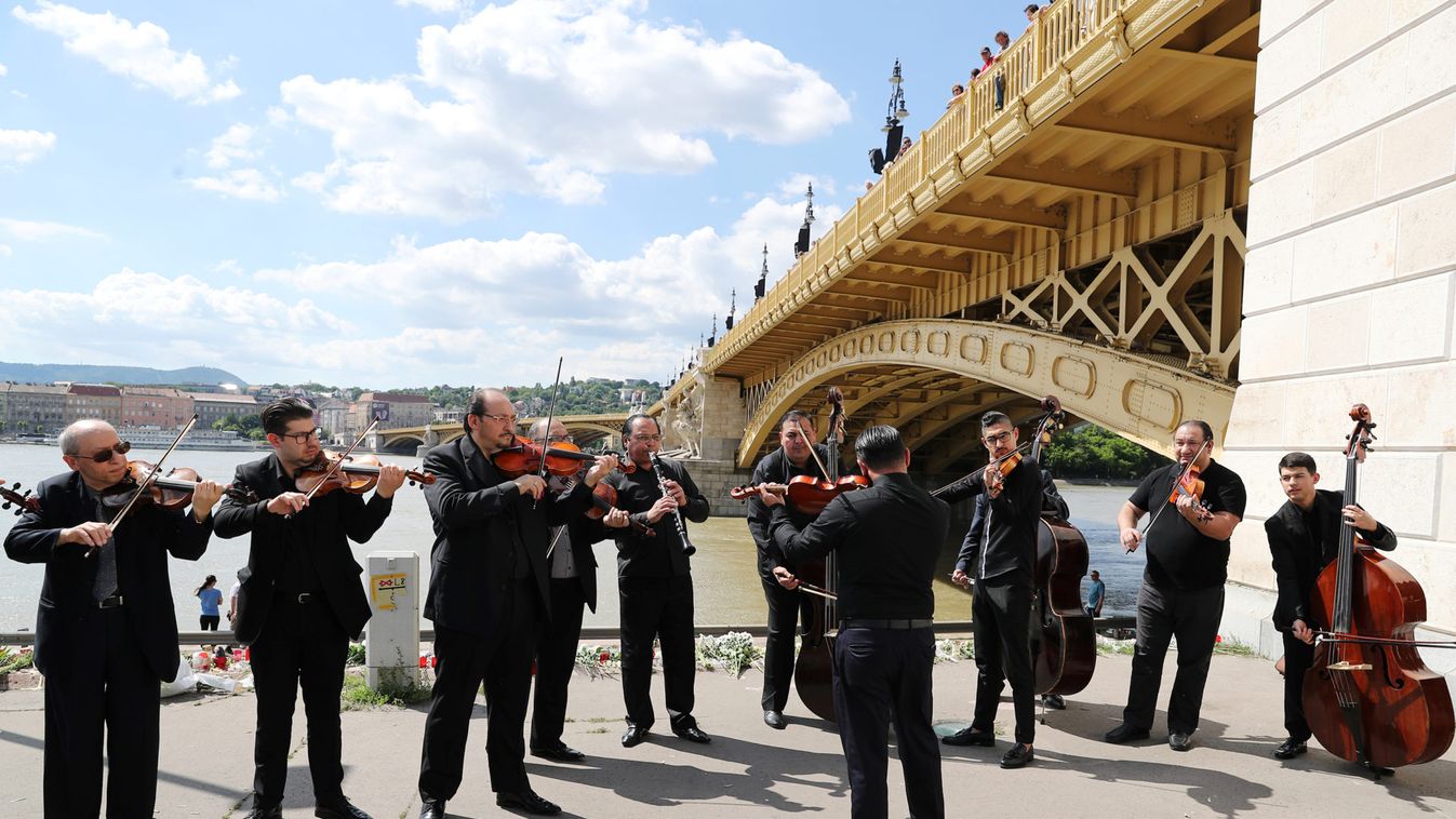 A music band plays music next to the Margaret bridge in respect for the victims from a boat carrying South Korean tourists capsized on the Danube river, in Budapest