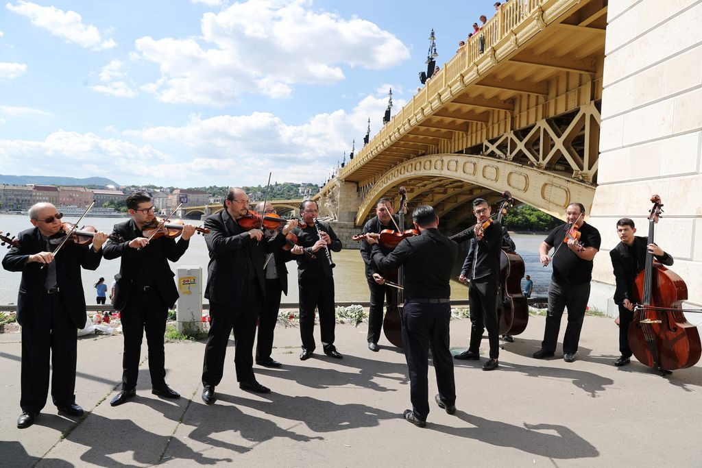 A music band plays music next to the Margaret bridge in respect for the victims from a boat carrying South Korean tourists capsized on the Danube river, in Budapest