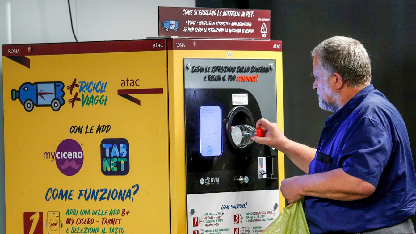 A man puts a plastic bottle into a recycling machine in San Giovanni metro station in Rome
