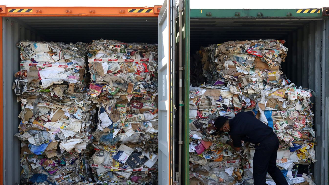 A customs officer inspects containers of waste paper imported from Australia at Tanjung Perak port in Surabaya, East Java province
