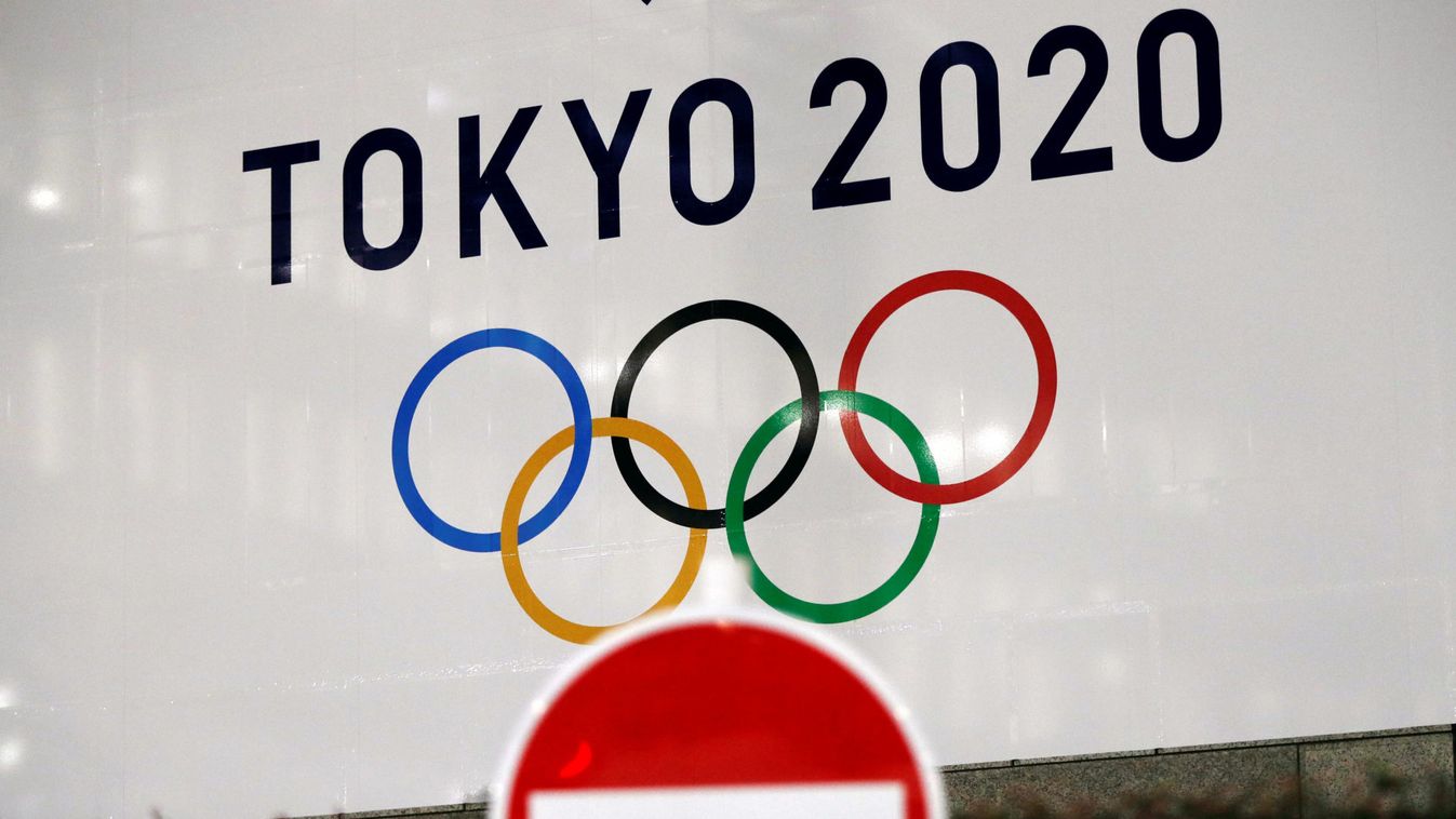 A banner for the upcoming Tokyo 2020 Olympics is seen behind a traffic sign in Tokyo, Japan