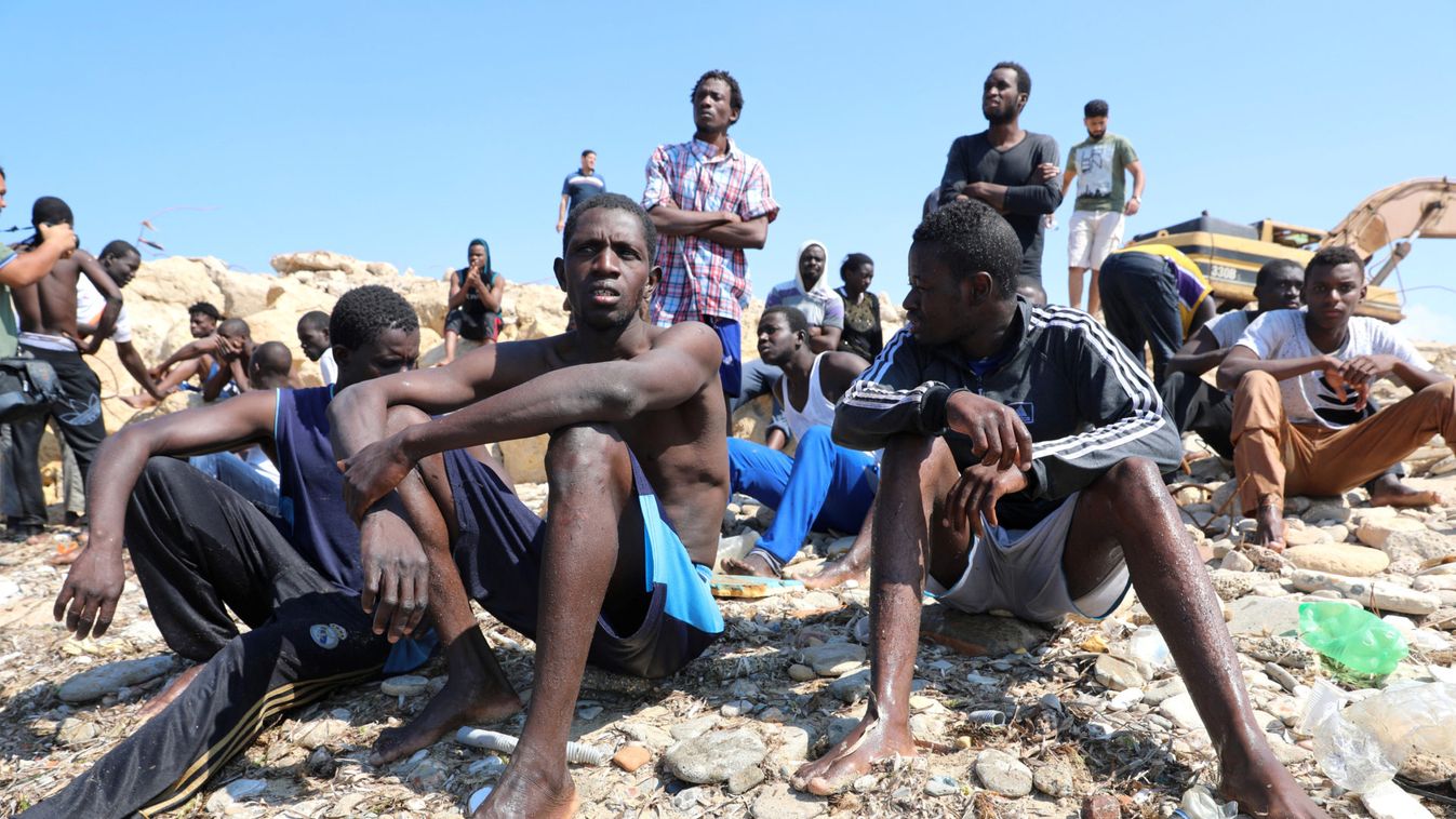 Migrants wait to be transported to a detention center, at the coast of Tajoura, east of Tripoli