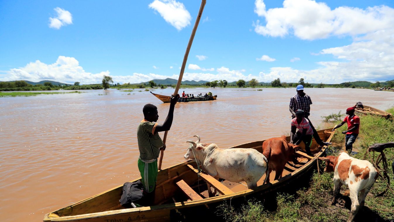 Residents use a boat to carry their cattle through the waters after their homes were flooded as the River Nzoia burst its banks and due to heavy rainfall and the backflow from Lake Victoria, in Budalangi within Busia County