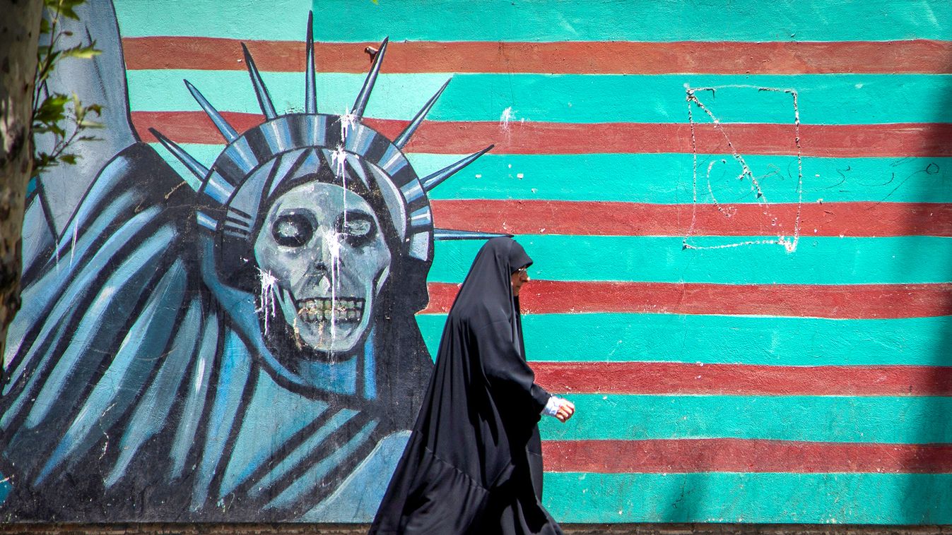 A woman walks in front of a mural depicting the Statue of Liberty in Tehran