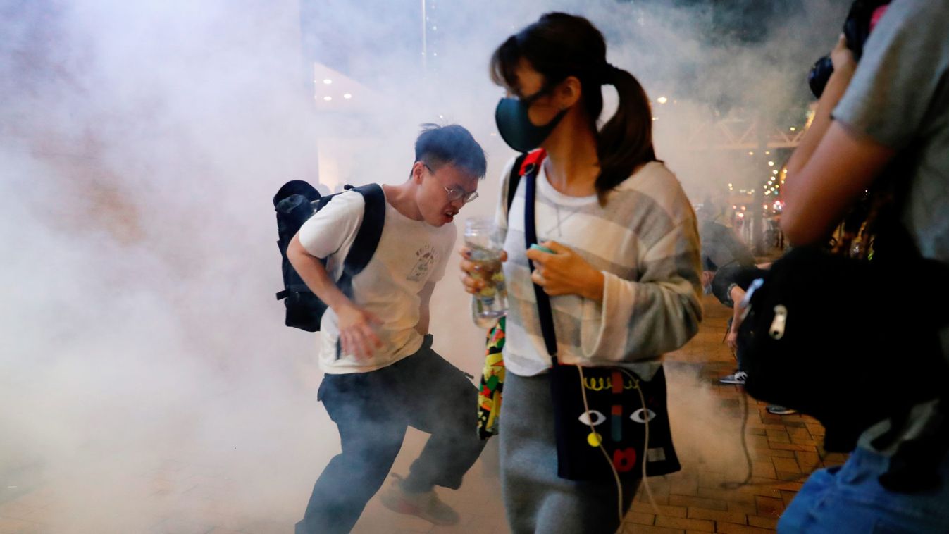 Anti-government protesters react from tear gas, in Hong Kong