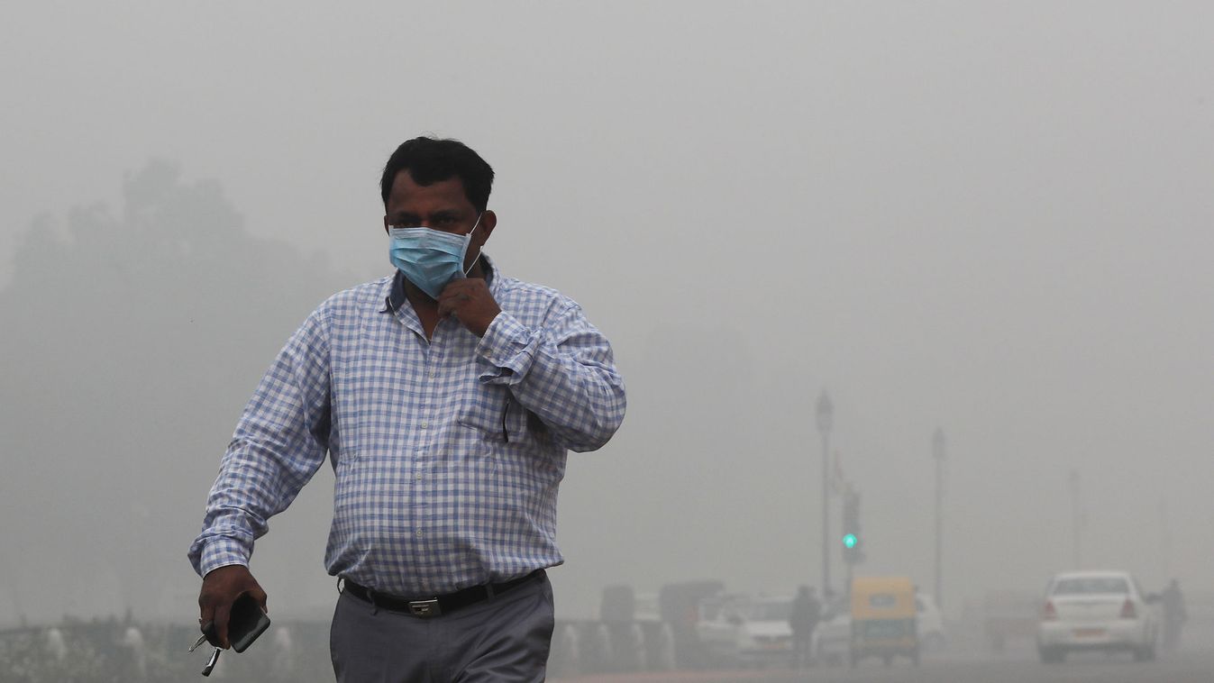 A man wearing a mask walks on a smoggy morning in New Delhi