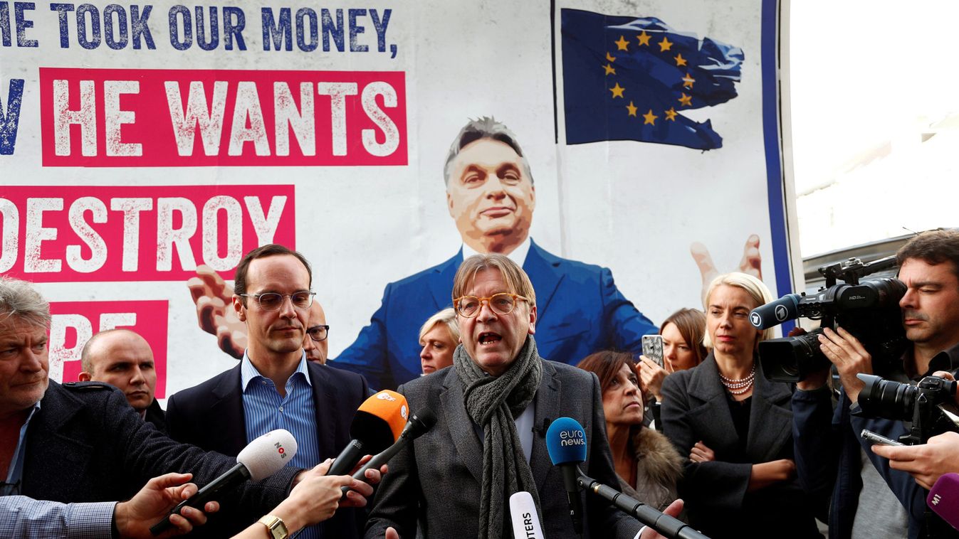 ALDE President Verhofstadt talks in front of an anti-Hungary's PM Orban billboard in Brussels