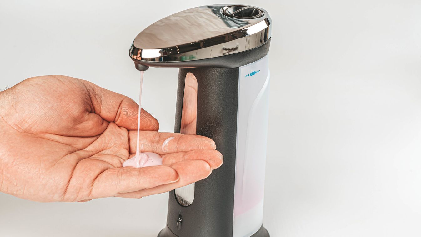 Close up of male hand uses automatic soap dispenser