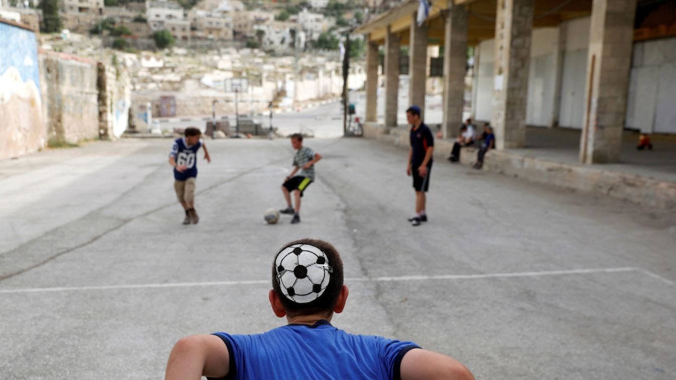 Dvir Gelman passes the ball as he plays with other Jewish children in the Jewish settlement in Hebron, in the Israeli occupied West Bank