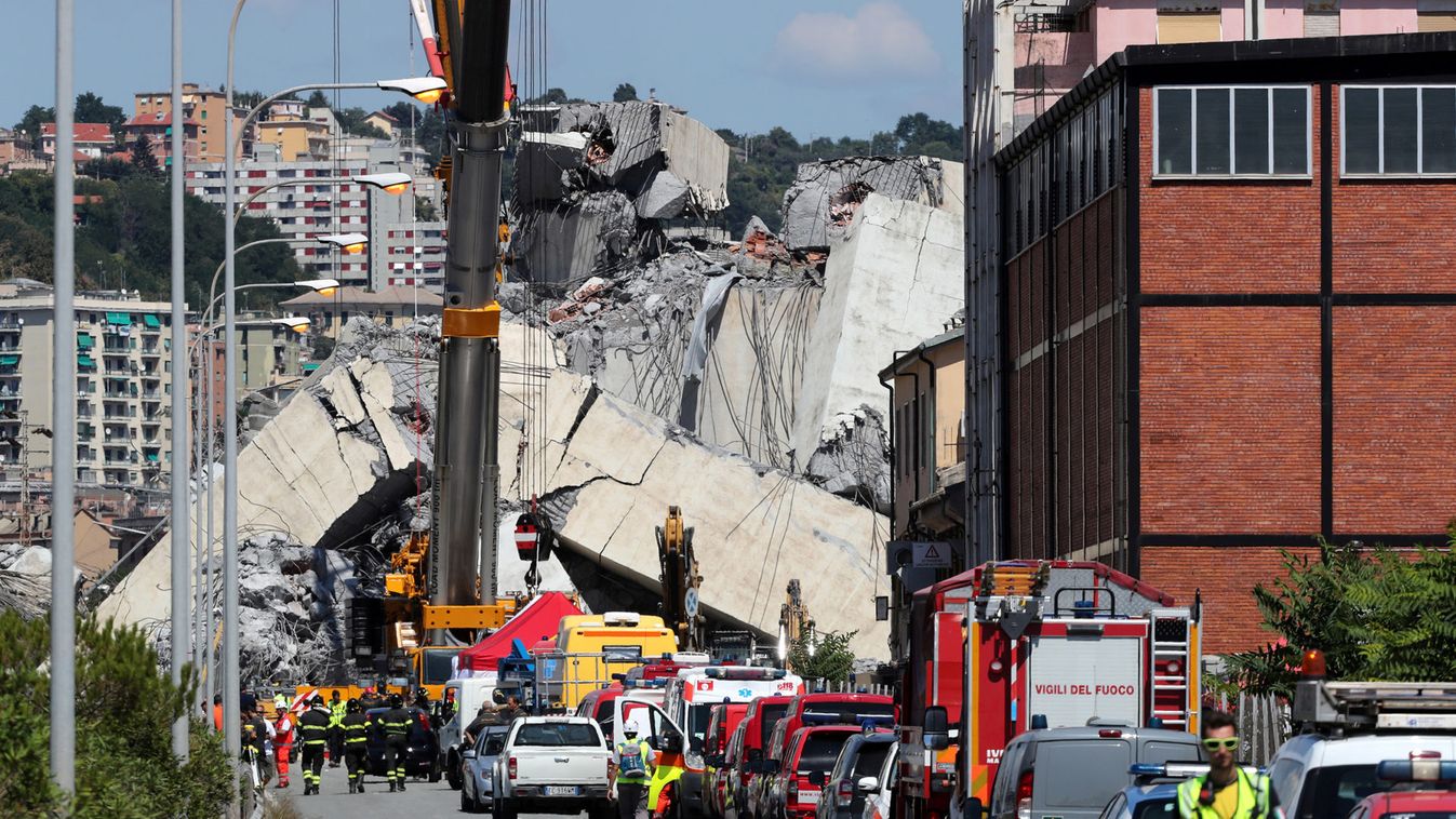 Firefighters and rescue workers stand at the site of a collapsed Morandi Bridge in the port city of Genoa