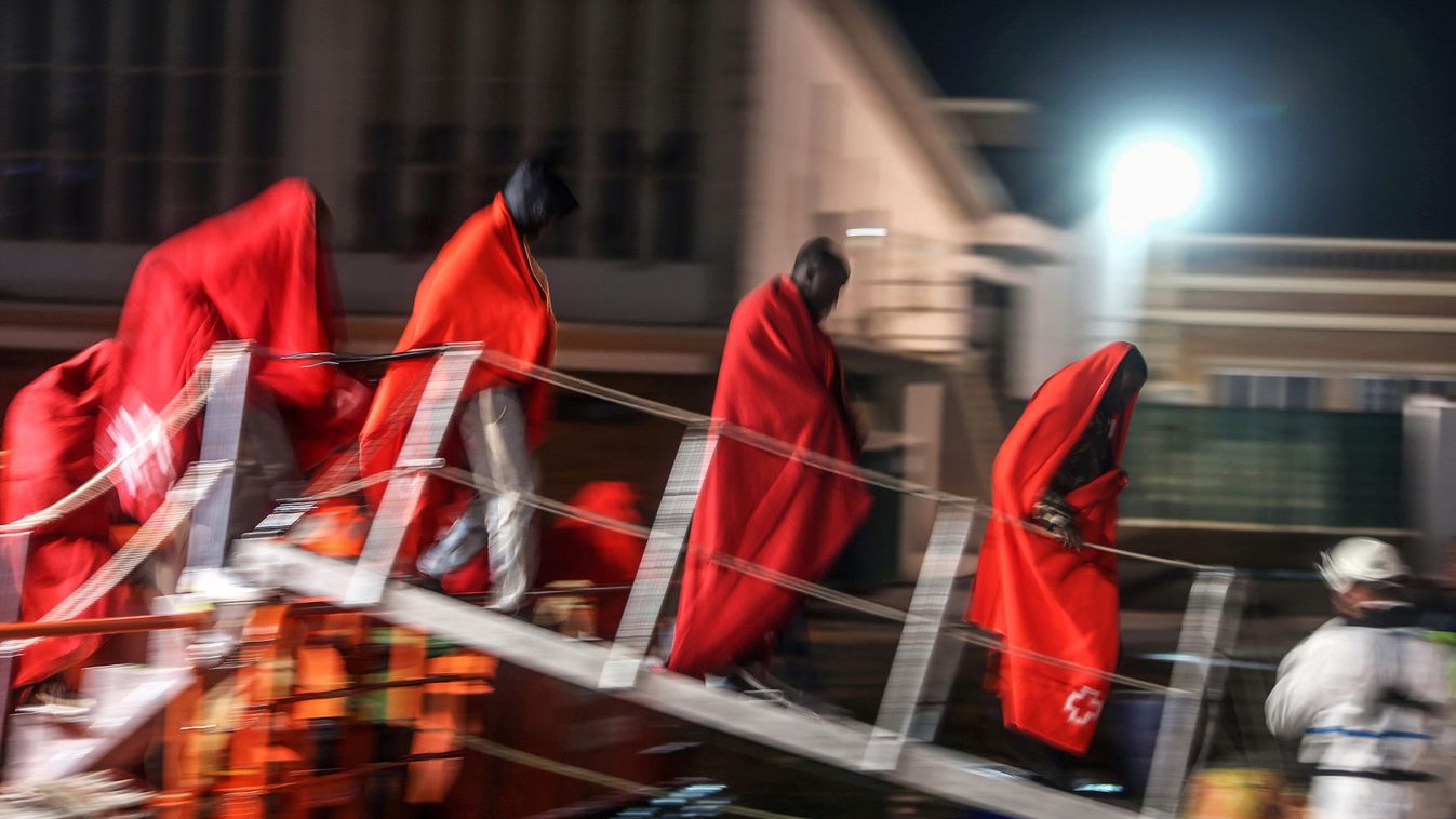 Migrants disembark a rescue boat after arriving at the port of Malaga