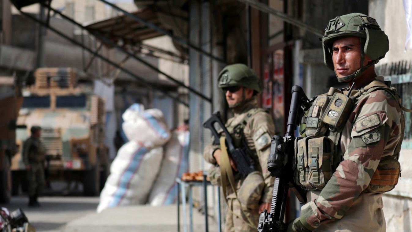 Turkish soldiers stand guard in the town of Tal Abyad