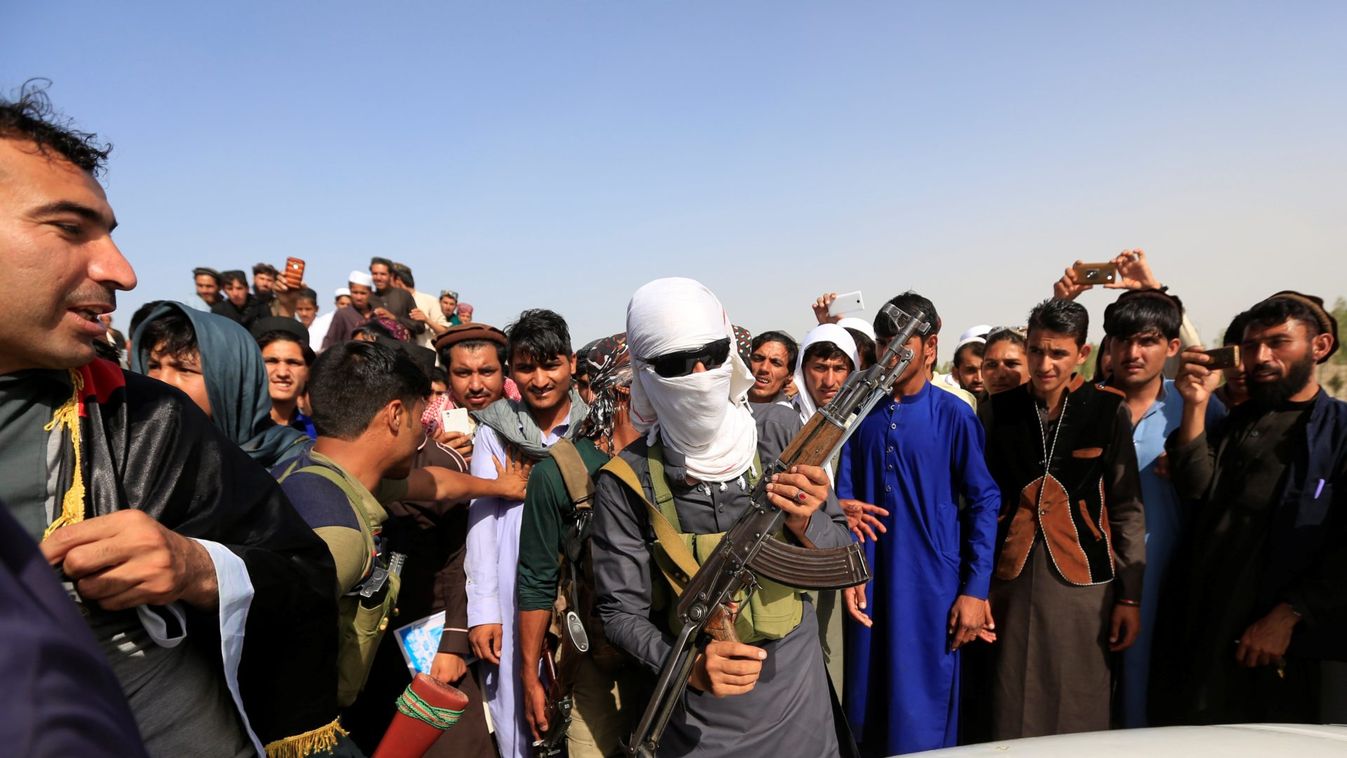 A Taliban (C) stands celebrates ceasefire with people in Rodat district of Nangarhar province, Afghanistan