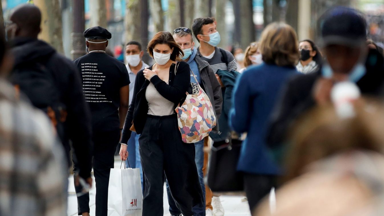 People wearing protective face masks walk in Paris