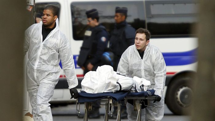 A victim is wheeled out of the Bataclan concert hall the morning after a series of deadly attacks in Paris