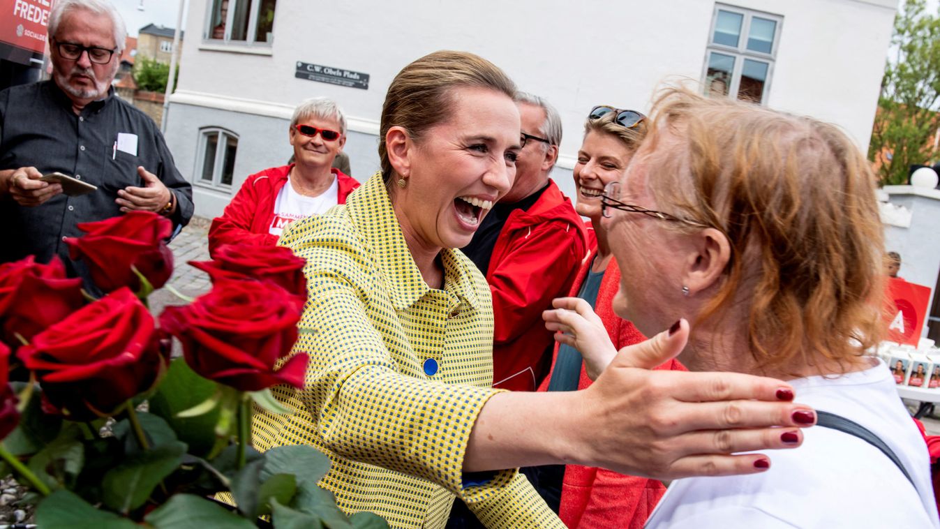 Leader of The Danish Social Democrats Mette Frederiksen gives flowers to voters along with Aalborg Mayor Thomas Kastrup-Larsen, during her last-minute campaign, during the parliamentary elections in her hometown Aalborg