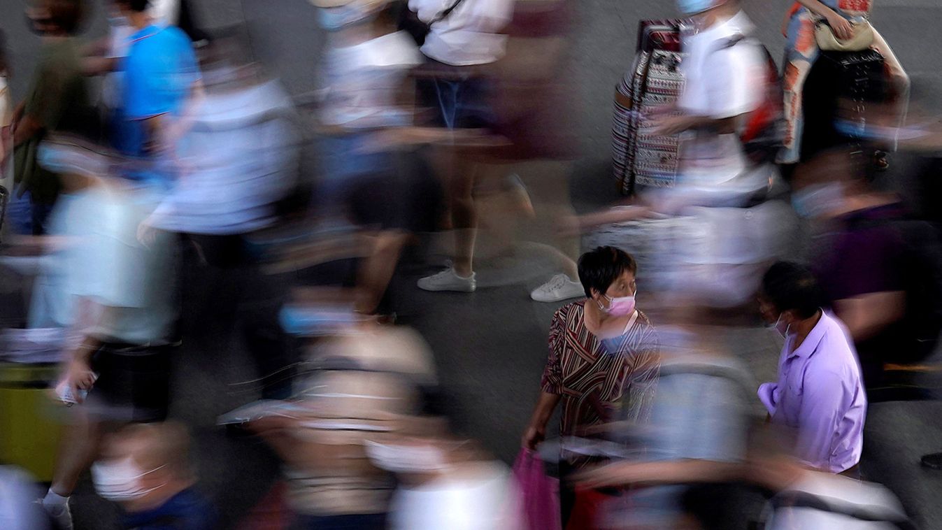 People wearing face masks wait for the train at Suzhou Railway Station in Suzhou