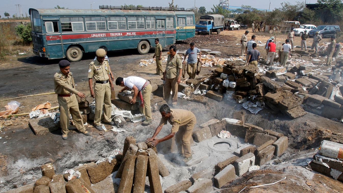 Policemen prepare to destroy seized cannabis at a dumping site on the outskirt of Agartala
