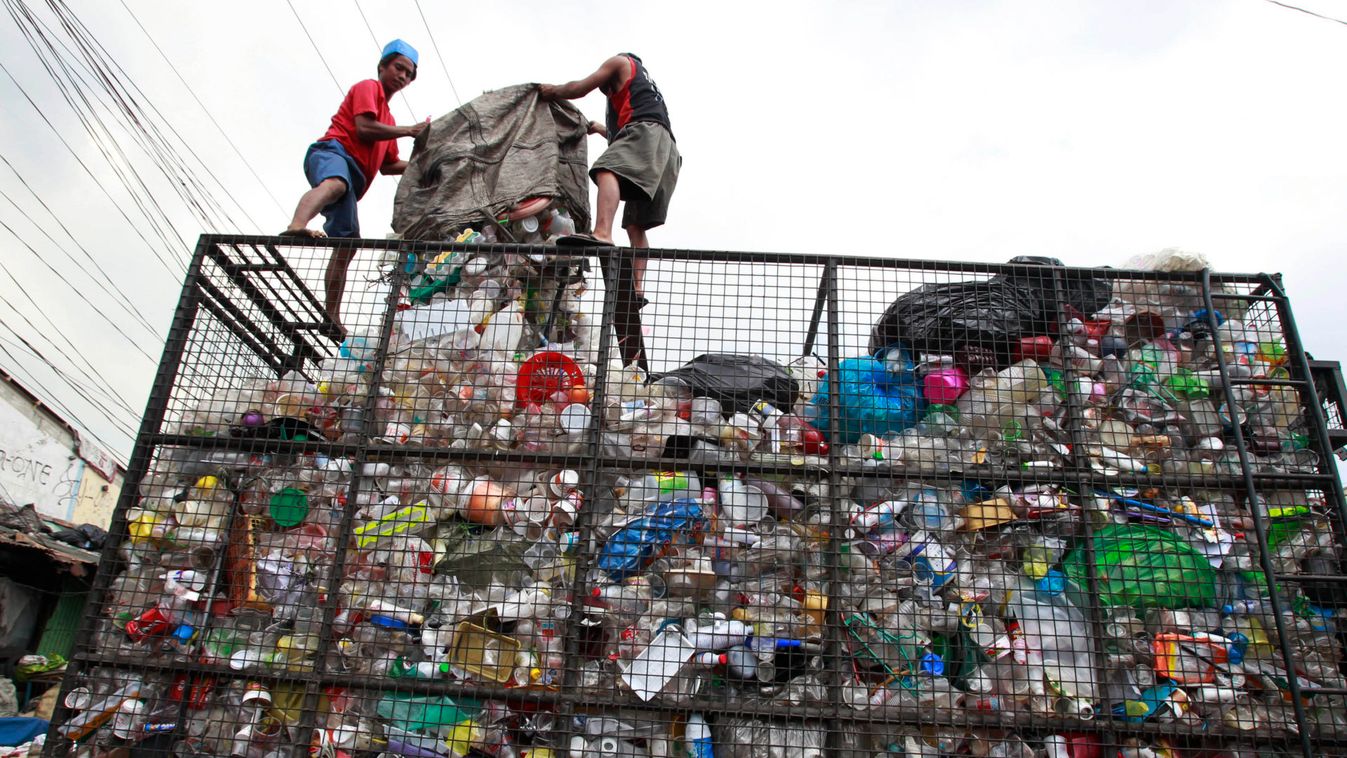 Workers load collected plastic bottles onto a truck at a junk shop in Manila