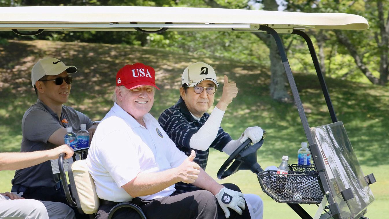 U.S. President Donald Trump sits on a cart as Japanese Prime Minister Shinzo Abe drives the cart as they play golf at Mobara Country Club in Mobara
