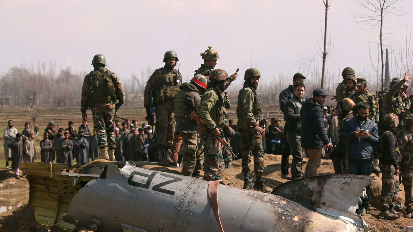 Indian soldiers stand next to the wreckage of IAF helicopter after it crashed in Budgam district