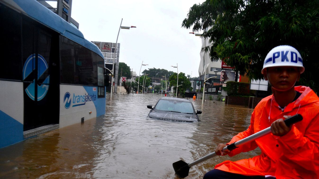 A security guard uses an inflatable boat as floods hit Kemang area in Jakarta