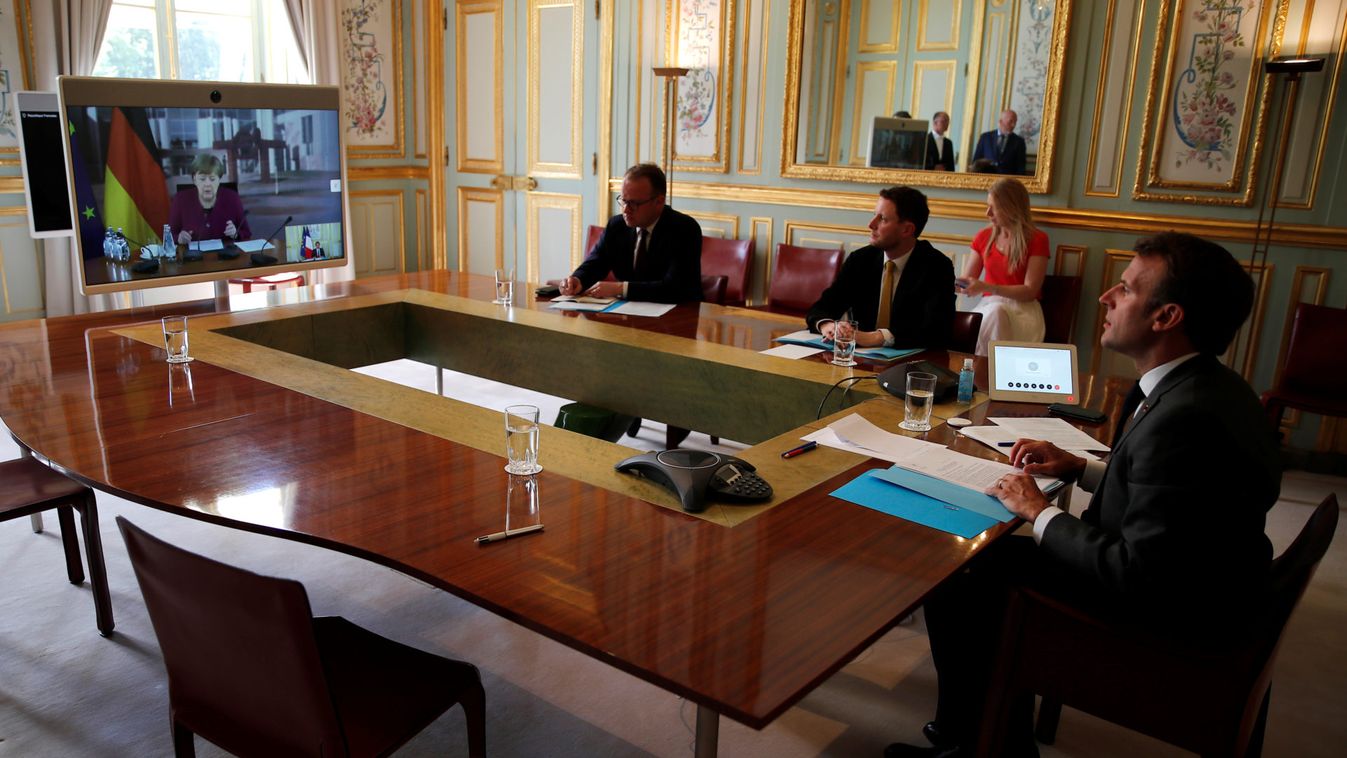 French President Emmanuel Macron listens to German Chancellor Angela Merkel during a video conference at the Elysee Palace