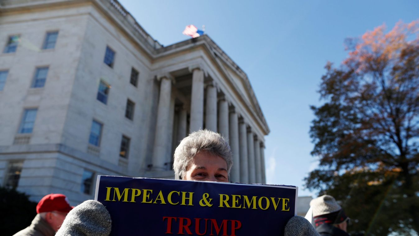 Protester holds placard outside of the Longworth building as the House Intelligence Committee holds the first public impeachment hearing on Capitol Hill