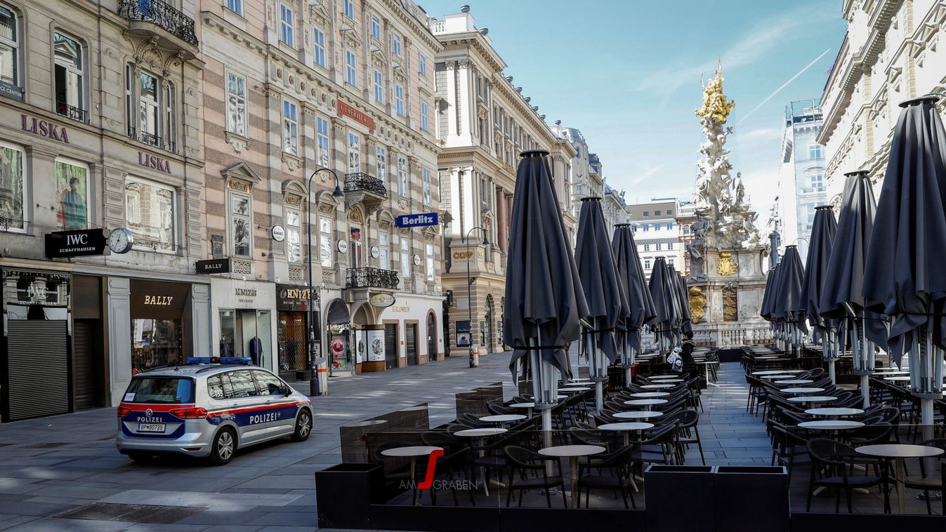 A police car passes an empty cafe in Vienna